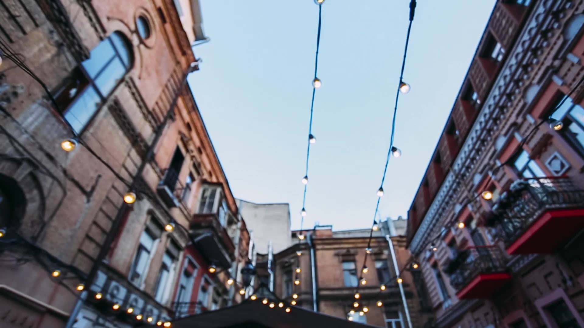 Historic street lined with buildings and overhead string lights